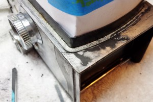 Paint removal from the Yashicaflex A-II body. There was plenty of corrosion on the cast aluminum body and the only way to attack it was with a good sanding with about 120 grit sandpaper followed by 220 grit.