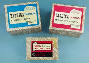 A small collection of boxes gives some idea as to the diversity of the early accessories. Note the general theme of the design... each shows-off the "pentaprism" design of the camera. The right angle finder box appears to be from a slightly later design as it has a different look from the other two.